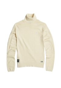 Maglione a collo alto di colore crema chiaro realizzato in morbido tessuto a maglia, con maniche lunghe e design aderente. Presenta un piccolo logo e un'etichetta.