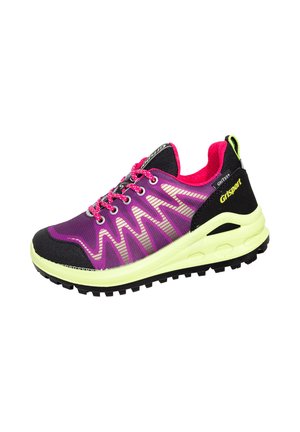 Lila und schwarze Sportschuhe mit einem Obermaterial aus Mesh, kontrastierenden pinken Akzenten, reflektierendem Zickzackmuster und einer klobigen gelben Sohle.