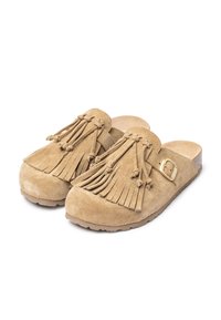 Suède klompen in tan met franjes, een goudkleurige gesp en een gevoerde voetbed. Laag profiel ontwerp met een textuurrubberzool.