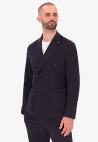 Blazer navy doppiopetto in tessuto elasticizzato con revers, due tasche frontali e quattro bottoni neri. Vestibilità liscia e sartoriale.