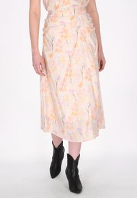Blumige Midirock aus leichtem Pfirsichstoff, der weiche Pastellmuster zeigt. Geraffte Details an der Taille und eine glatte, fließende Silhouette.