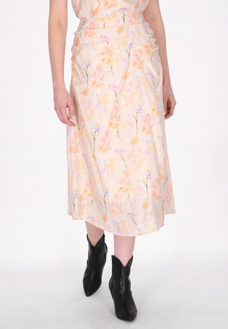 Blumige Midirock aus leichtem Pfirsichstoff, der weiche Pastellmuster zeigt. Geraffte Details an der Taille und eine glatte, fließende Silhouette.