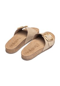 Sandales à glissière en suède beige avec une semelle en liège, dotées d'une large sangle et d'un accent en boucle dorée. Nom de la marque imprimé sur la semelle intérieure.