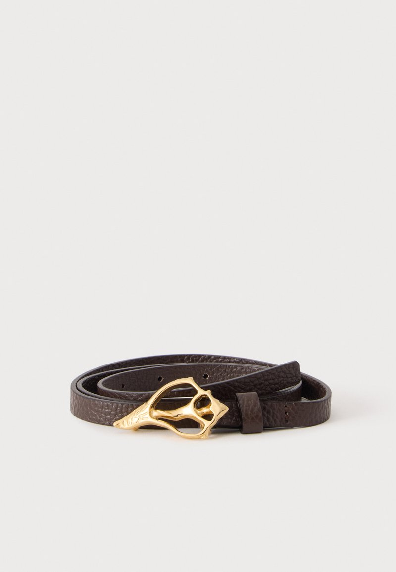 Ceinture en cuir marron foncé enroulée avec une boucle décorative couleur or sur un fond clair uni.
