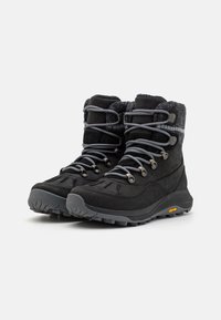 Sorte vanntette støvler med overdel i semsket skinn og syntetisk materiale, med grå snøkker, en fluffy krage og en robust Vibram såle.
