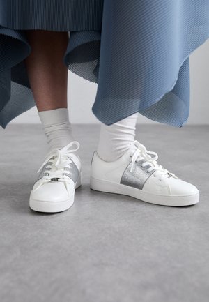 Witte sneakers met zilveren accenten en veters, met een gladlederen afwerking. Ze hebben een eenvoudig, laag model en een ronde neus.