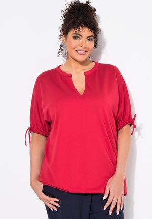 Blouse rouge à manches courtes avec un col en V, des manches froncées et des liens aux poignets. Fabriquée en tissu lisse avec une coupe décontractée.