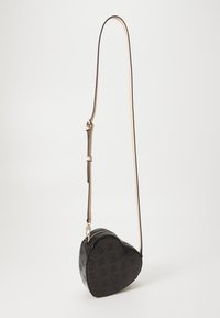Svart hjerteformet crossbody-veske laget av patenter skinn med preget mønster, med glidelås lukking og justerbar stropp.