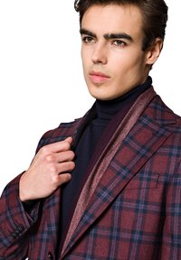 Marynarka w kratę w bordowych, granatowych i szarych odcieniach. Posiada strukturalne klapy, kontrastowy szalik i teksturowane wykończenie.