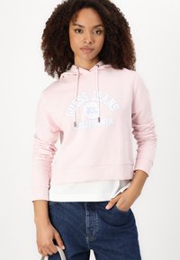 Felpa cropped rosa realizzata in morbido cotone, con stampa del logo frontale in bianco e blu. Ha un cappuccio con cordino e polsini a costine.