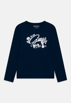 Marineblå langærmet skjorte med hvidt blomsterdesign og teksten "Guess Est. 1981 Los Angeles" midt foran.