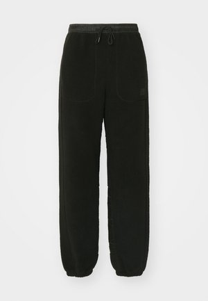 Black fleece sweatpants with an elastic waistband and drawstring. Features two front pockets and tapered cuffs at the ankles.