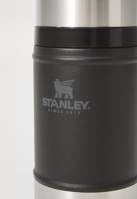 Black stainless steel thermos with a smooth matte finish and chrome top. Features engraved logo and text "STANLEY SINCE 1913."