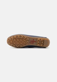 Scarpa navy con suola in gomma dotata di un motivo testurizzato per una presa migliore. Accenti rossi e beige alla base della suola per una maggiore trazione.
