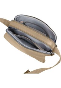 Beige crossbody taske med struktureret overflade, der har et rummeligt interiør med to rum, sølvfarvede lynlåse og en bred justerbar skulderrem.