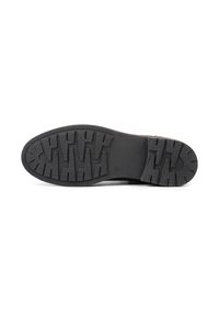 Suela de zapato de goma negra con un patrón de textura en la banda de rodamiento, punta redondeada y área del talón lisa. Duradera y con tracción para un buen agarre.