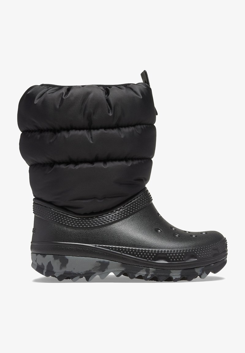 Botte étanche noire avec un haut en nylon rembourré, un bas en caoutchouc texturé et une semelle robuste à motif. Comprend une languette pour un enfilage facile.