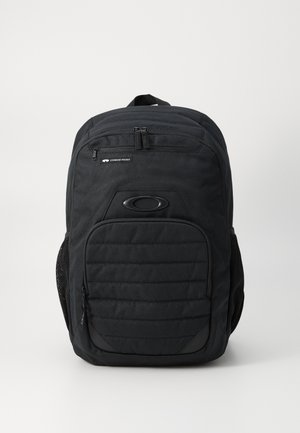 Black backpack with a structured design, featuring a front zip pocket, padded back, and mesh side pockets. Material appears durable.