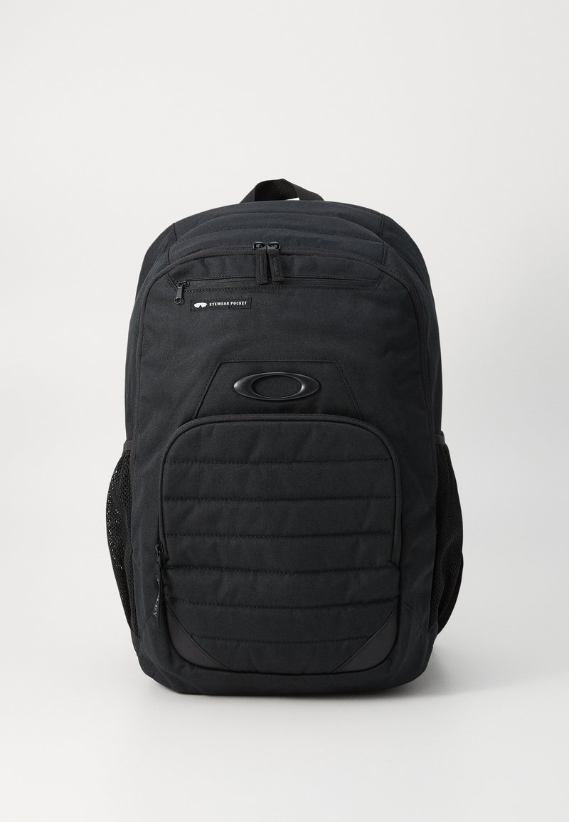 Zwarte rugzak met een gestructureerd ontwerp, voorzien van een voorvak met rits, een gevoerde achterkant en netzijvakken. Het materiaal lijkt duurzaam.