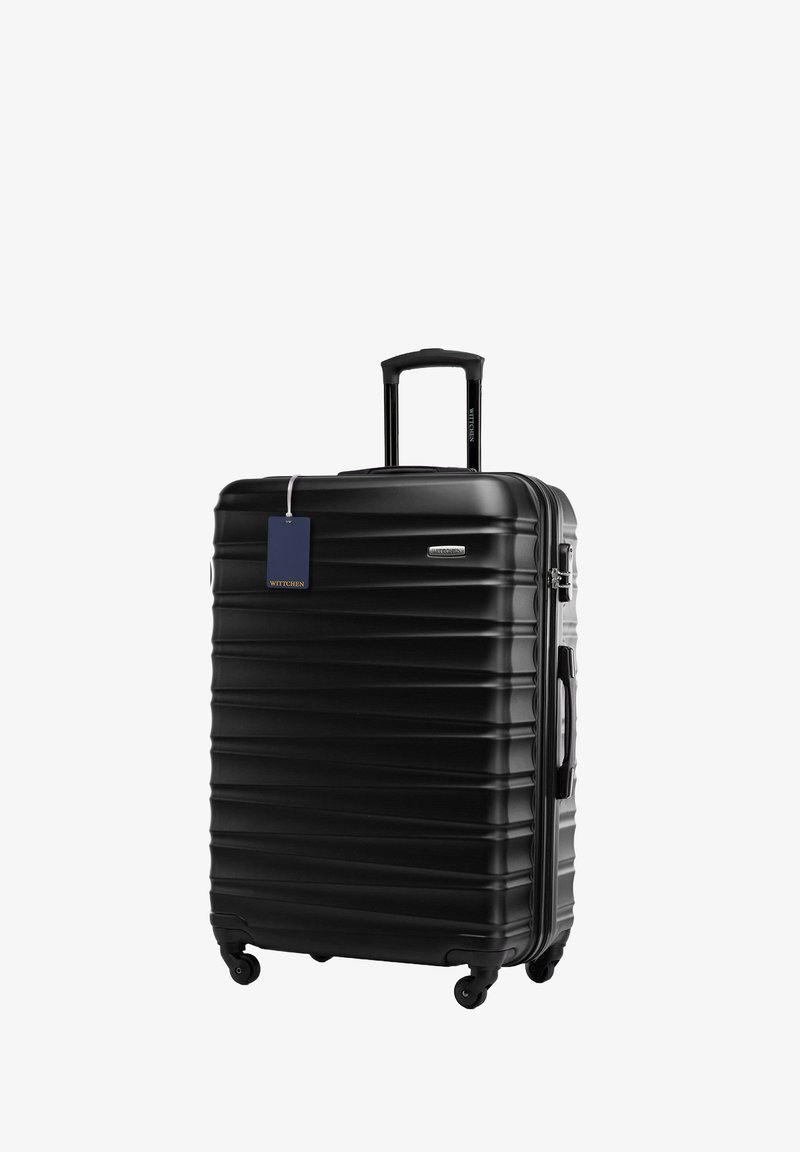 Černý tvrdý kufr s žebrovanou texturou, výsuvnou rukojetí, čtyřmi kolečky a modrou visačkou na zavazadlo. Kompaktní obdélníkový tvar.