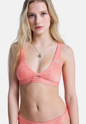 Koralowy top bikini w białe poziome paski, z głębokim dekoltem w kształcie litery V i zawiązanym węzłem na środku. Gładka tkanina z lekkim połyskiem.