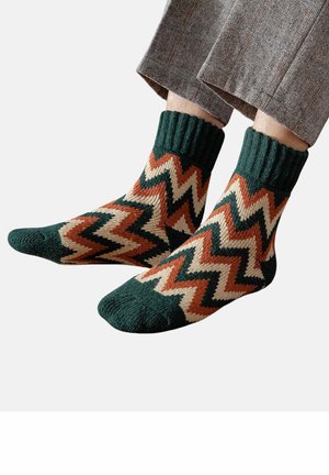 Mehrfarbige Socken mit einem Zickzackmuster in Grün, Braun und Creme. Gerippter Bund, gestrickte Textur und knöchellanges Design.