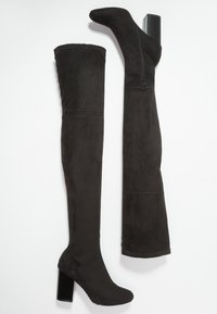 Sorte over-knæ støvler lavet af blødt suede, med en firkantet blokhæl og lynlås i siden, med en glat tekstur og slank silhuet.