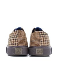 Bruine geweven sneakers met een geruit patroon, textielstof, donkere rubberen zolen en een blauwe binnenvoering. Branding is zichtbaar op de hiel.