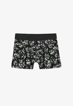 Musta bokserialushousut, joissa on valkoinen kukkakuvio. Valmistettu joustavasta kankaasta, mustalla elastisella vyötärönauhalla mukavuutta varten.