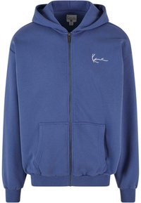Blå zip-up hoodie lavet af blødt stof med frontlommer, ribbede manchetter og elastisk talje. Har et lille hvidt logo på brystet.