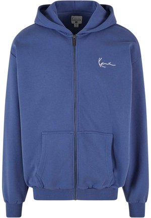 Blå zip-up hoodie lavet af blødt stof med frontlommer, ribbede manchetter og elastisk talje. Har et lille hvidt logo på brystet.