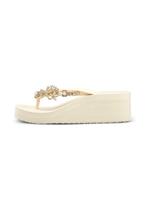 Sandalia beige de cuña con tiras decoradas en tono dorado con perlas y pedrería, mostrada en perfil lateral sobre fondo blanco.