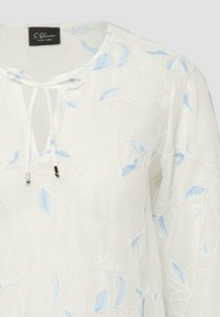 Biała bluzka z jasnoniebieskim kwiatowym haftem, okrągłym dekoltem i wiązaniem z przodu z metalowymi końcówkami, oznaczona jako S.Oliver Black Label.