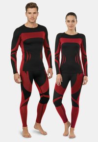Black athletic tops and leggings with red abstract patterns. The fabric appears textured with long sleeves and fitted design.