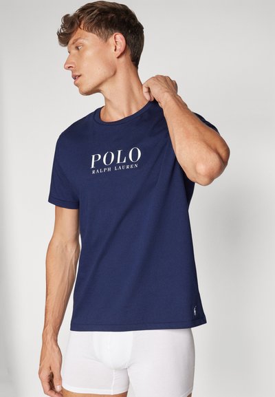 Sötétkék pamut póló kerek nyakkivágással, elöl fehér "POLO RALPH LAUREN" logóval, rövid ujjú és egyenes szegéllyel.