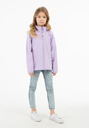Giacca zip-up di un leggero color viola con colletto alto, due tasche laterali e un tirante decorativo per la cerniera. Abbinata a jeans di denim chiaro e sneakers bianche.