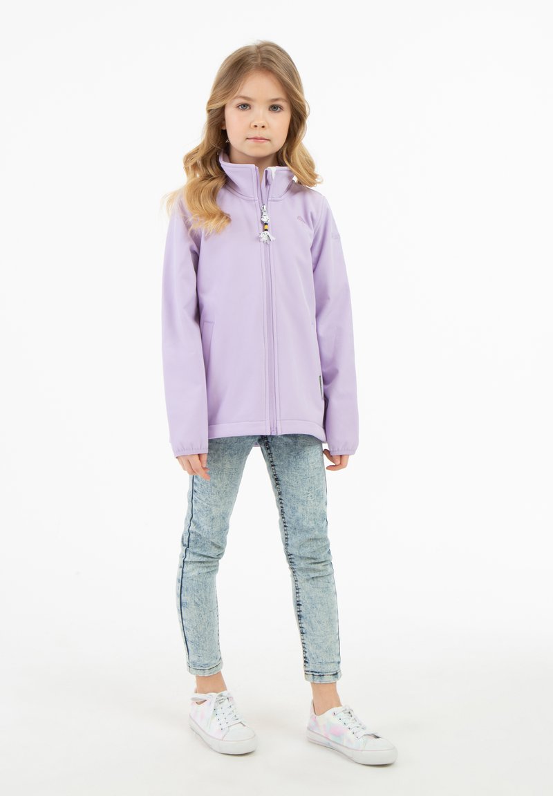 Ljuslila zip-up-jacka med ståkrage, två sidofickor och en dekorativ dragkedja. Matchad med ljusa denimjeans och vita sneakers.