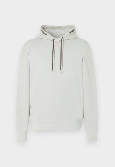 Ανοιχτό γκρι φούτερ με κουκούλα και ρυθμιζόμενα καφέ κορδόνια, κεντημένο λογότυπο στο στήθος, απαλό ύφασμα και ριμπ μανσέτες και τελείωμα.
