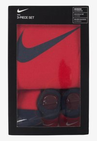 Nike 3-delt sett i rødt, inkludert en heldrakt, lue og smekker. Har marineblå detaljer og logo. Pakket i en svart presentasjonsboks.