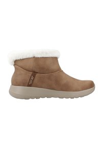 Bruine suède enkellaars met een witte faux fur manchet en een lichtgrijze rubberen zool. Heeft een zijnaaddetail en een merklogo op de hak.