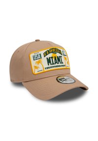 Gorra de béisbol beige con una corona estructurada, que presenta un parche bordado con "Florida Miami" y palmeras. Con visera curvada.