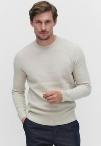 Ljusgrå crewneck-tröja gjord av mjuk ull. Har ribbade mudd och nederkant. Enkelt design med en slät ytstruktur och minimal detaljering.