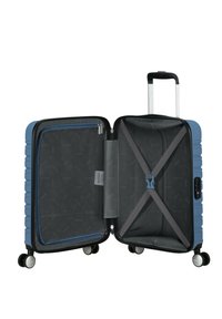 Valise rigide bleue avec une double fermeture éclair, poche en mesh à l'intérieur, sangles grises et quatre roues ; ouverte pour révéler un compartiment spacieux.