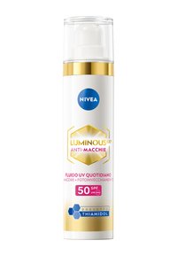 Bottiglia cilindrica bianca con un tappo a pompa trasparente. Accenti dorati, logo blu e testo rosa evidenziano la protezione SPF 50 e le caratteristiche anti-macchia.