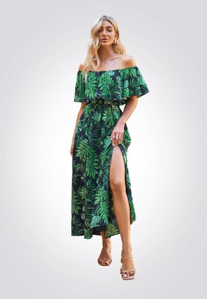 Vestido maxi sin hombros en verde oscuro con un patrón de hojas tropicales, que presenta una alta abertura y una cintura elástica para una silueta fluida.