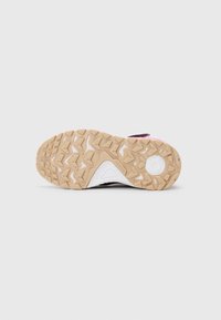Zool van een beige rubberen wandelschoen met diepe profiel, witte archsupport met merknaam en een rond logo nabij de hiel.