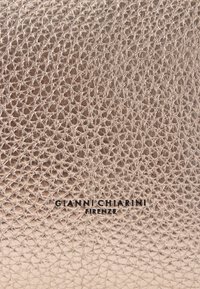 Håndtaske i metalisk rosaguld læder med et struktureret vævet mønster. Har præget mærkenavn "GIANNI CHIARINI FIRENZE" i sort.