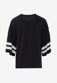 Zwart oversized T-shirt met korte mouwen en witte horizontale strepen op de manchetten; gemaakt van een zachte, lichte stof.