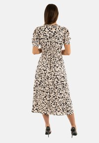 Abito midi floreale con vita aderente, maniche corte a sbuffo e una palette di colori bianco e nero; tessuto morbido ed elegante silhouette.