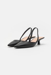 Mustad nahast slingback kingad terava varbaga, minimalistlik disain, väike plokkninak ja avatud selg hõlpsaks jalga panemiseks.
